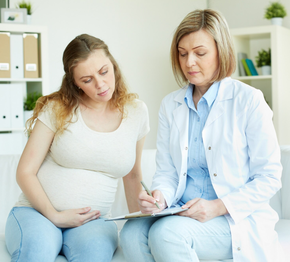 Gynecologist consulting pregnant patient and documenting care with AI Scribe for Gynecologists