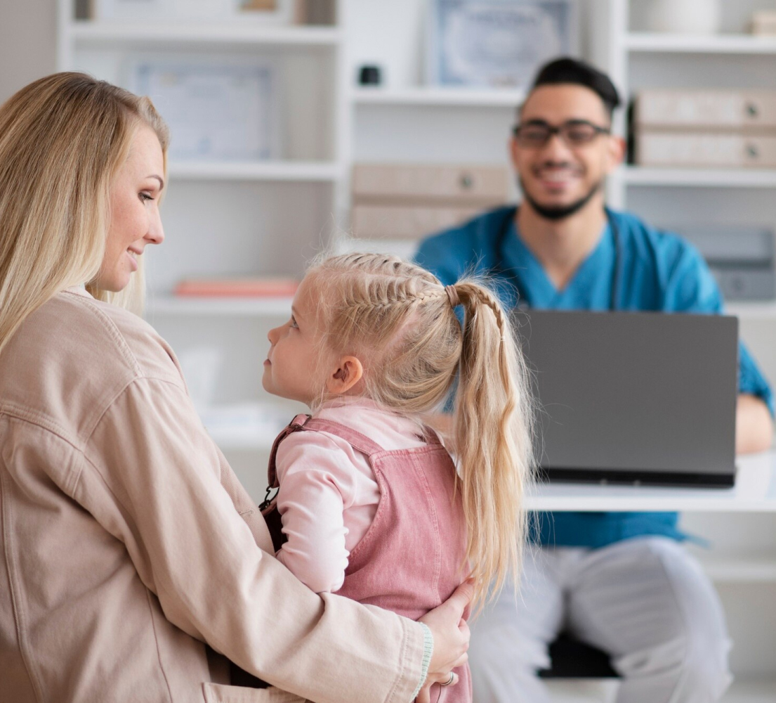Pediatrician interacting with mother and child, supported by AI Scribe for Pediatrics software.